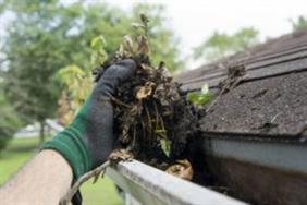 Homeowner cleaning gutters